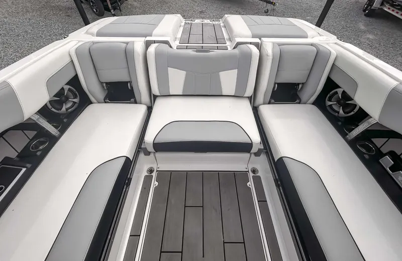 Slide: The Image of 2020 Malibu 23 MXZ boat interior with gray and white seating and speakers. - 17