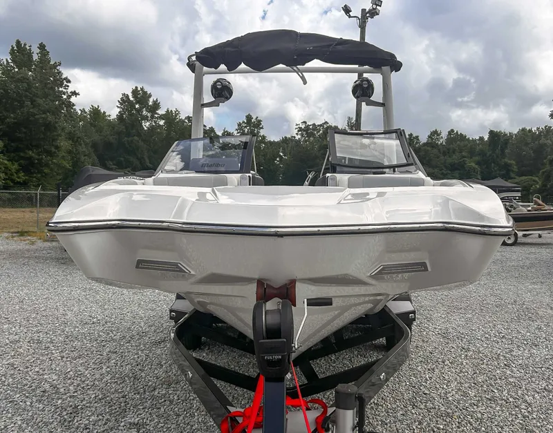 Slide: The Image of 2020 Malibu 23 MXZ boat on trailer, parked outdoors under cloudy sky. - 3