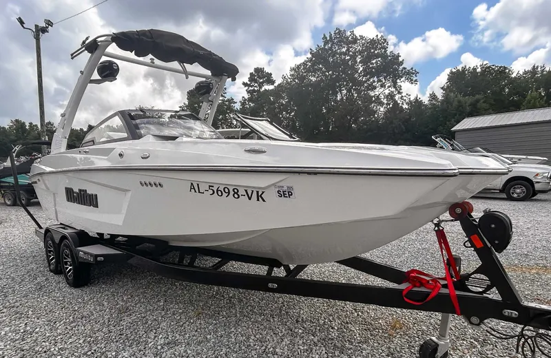 Slide: The Image of 2020 Malibu 23 MXZ boat on trailer, parked outdoors under cloudy sky. - 4