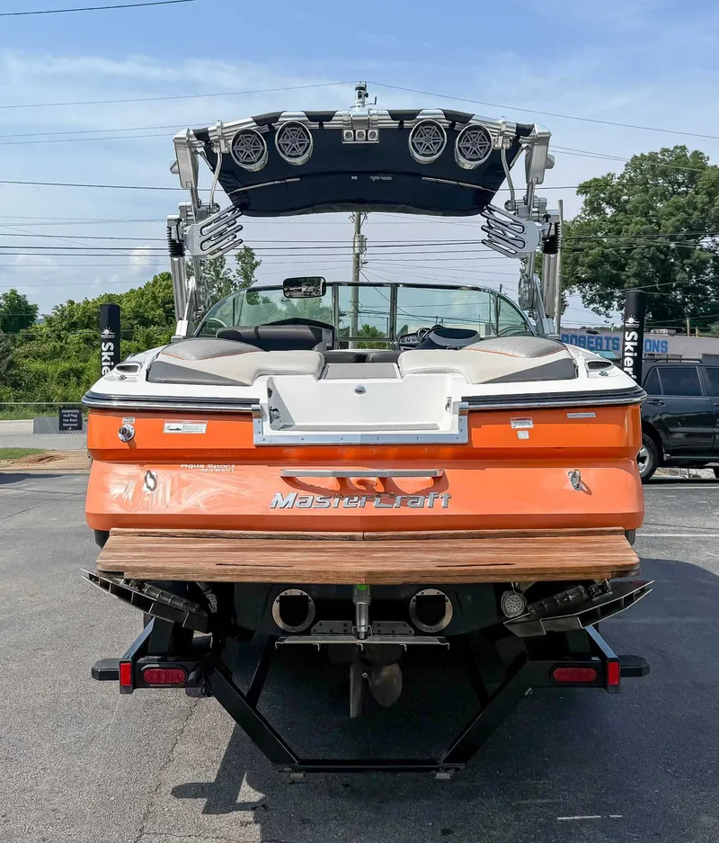 Slide: The Image of 2012 MasterCraft X55 boat, orange exterior, rear view with speakers and seating. - 9