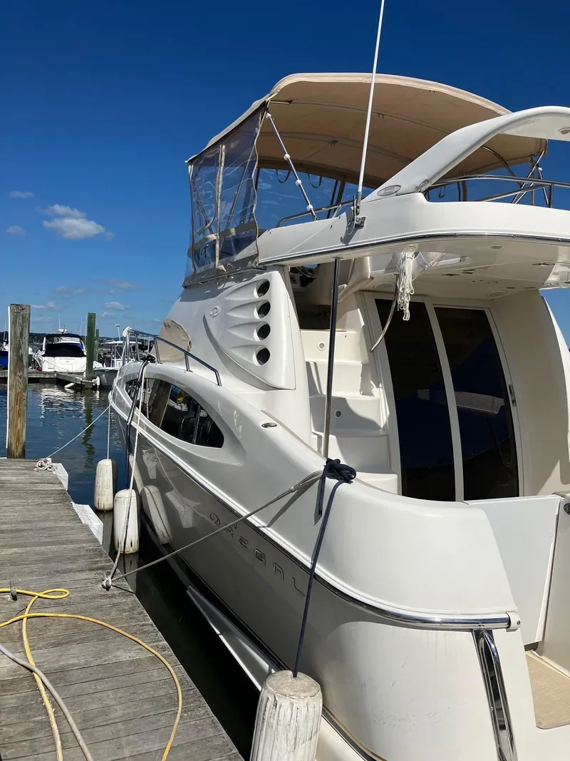 The Image of 2002 Regal Commodore 3880 yacht docked at marina under clear blue sky. - 0