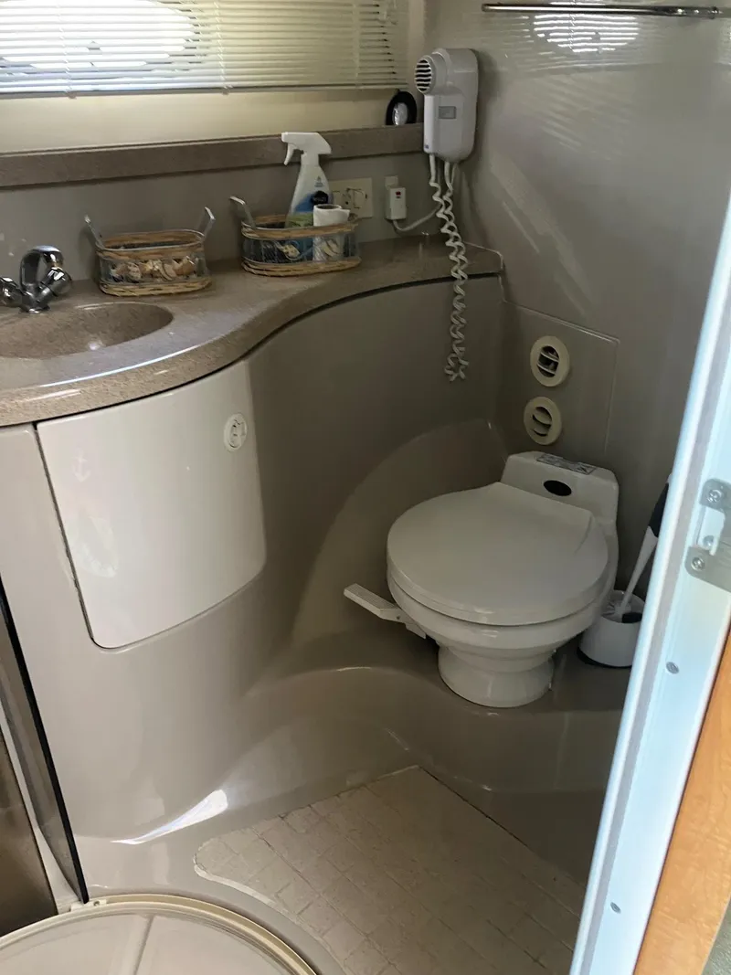 Slide: The Image of 2002 Regal Commodore 3880 yacht bathroom with sink, toilet, and phone. - 13