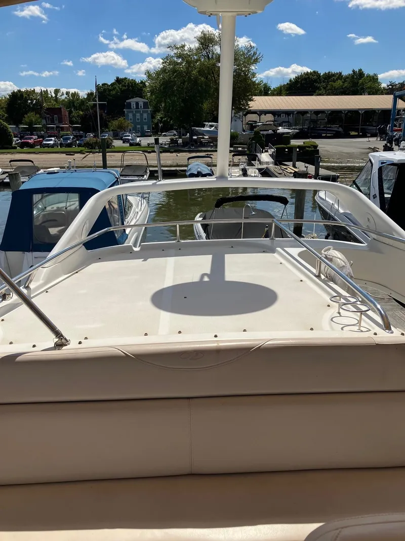 Slide: The Image of 2002 Regal Commodore 3880 yacht docked at marina under clear blue sky. - 4