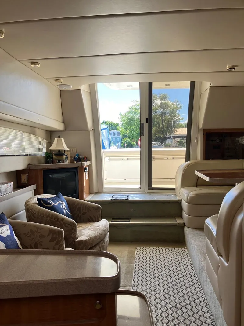 Slide: The Image of Interior of 2002 Regal Commodore 3880 yacht, featuring cozy seating and elegant decor. - 9