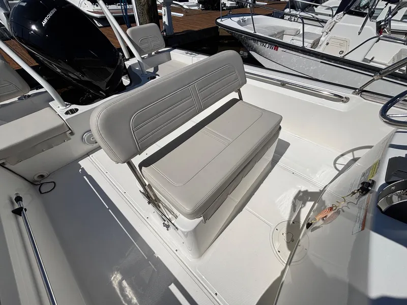 Slide: The Image of 2023 Boston Whaler 190 Montauk boat interior with seating and Mercury engine. - 11