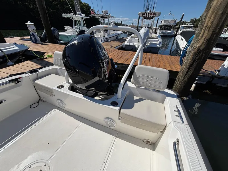 Slide: The Image of 2023 Boston Whaler 190 Montauk boat interior at dock, featuring seating and motor. - 13