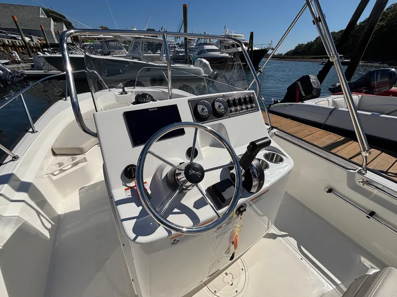 Slide: The Image of 2023 Boston Whaler 190 Montauk boat console with steering wheel and controls at dock. - 14