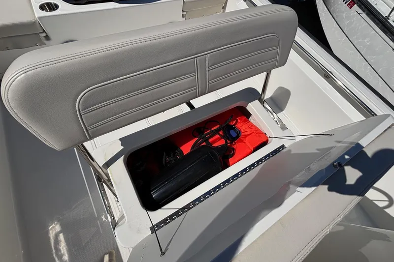 Slide: The Image of 2023 Boston Whaler 190 Montauk boat seat storage compartment with safety gear and accessories. - 15