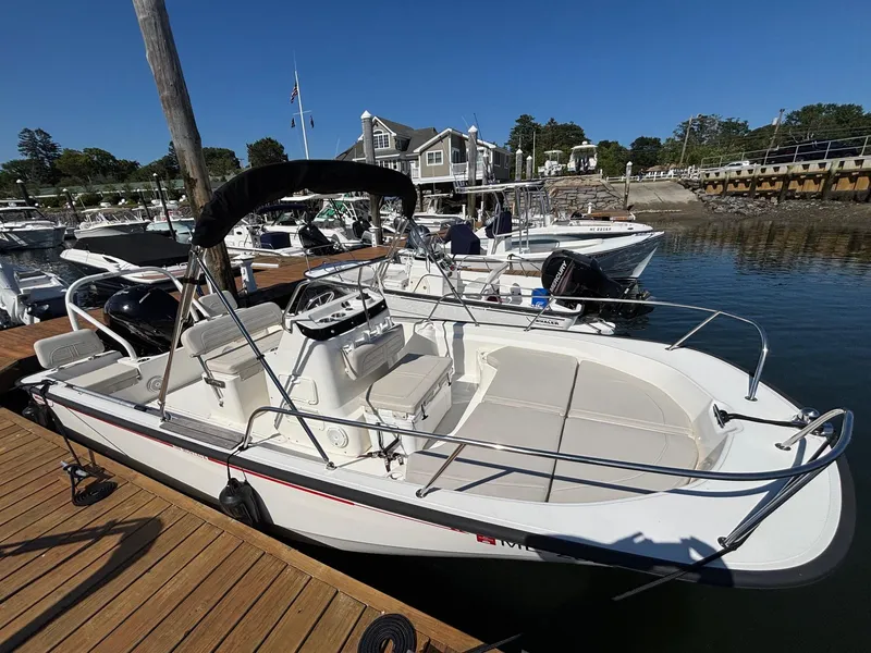 Slide: The Image of 2023 Boston Whaler 190 Montauk boat docked at a marina under clear blue skies. - 3