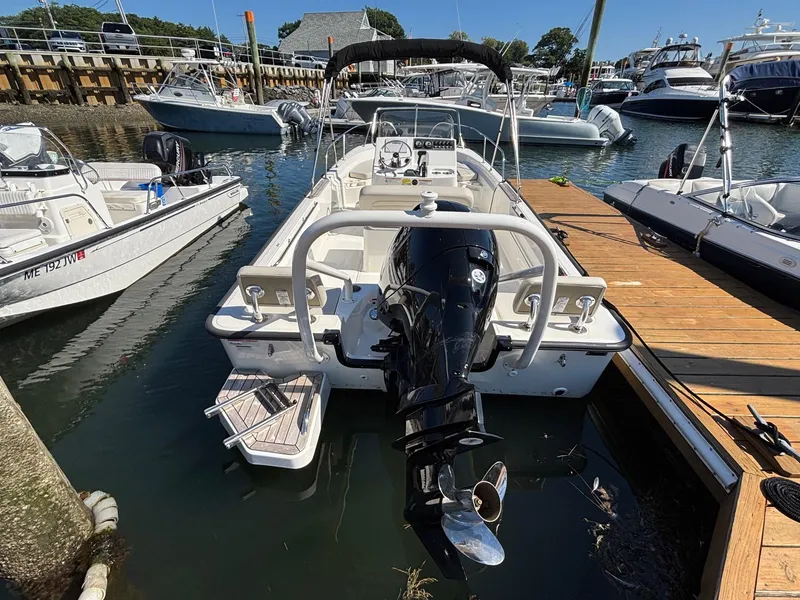 Slide: The Image of 2023 Boston Whaler 190 Montauk docked at marina, rear view with outboard motor. - 4