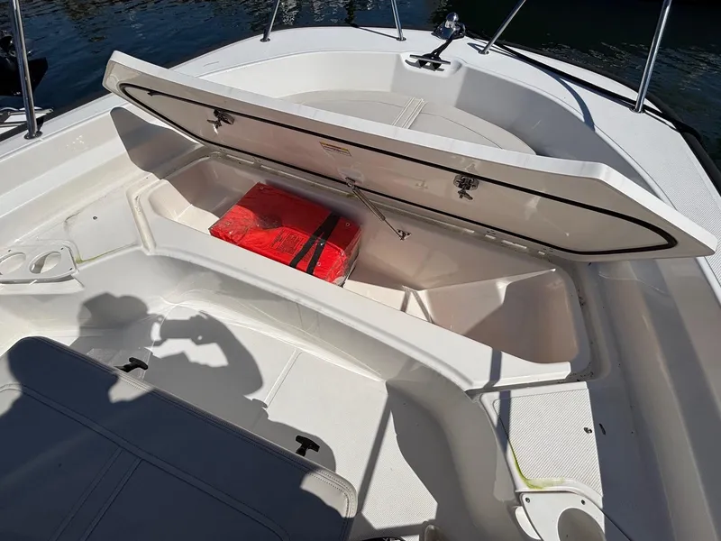 Slide: The Image of 2023 Boston Whaler 190 Montauk boat storage compartment with red life jacket inside. - 8