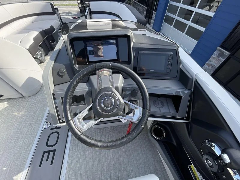 Slide: The Image of 2024 Tahoe Pontoon 23 Cascade Versatile Rear Lounger dashboard with steering wheel and digital displays. - 20