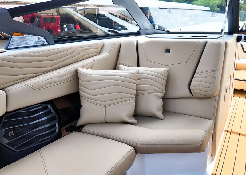 Slide: The Image of 2025 Nautique G23 boat interior with beige leather seating and cushions. - 12
