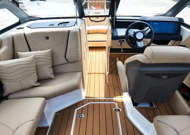 Slide: The Image of 2025 Nautique G23 boat interior with luxurious seating and modern dashboard design. - 13