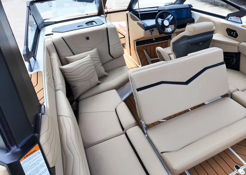 Slide: The Image of Luxurious interior of 2025 Nautique G23 boat with beige seating and modern dashboard. - 4