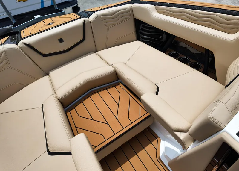 Slide: The Image of 2025 Nautique G23 boat interior with beige seating and teak-style flooring. - 6