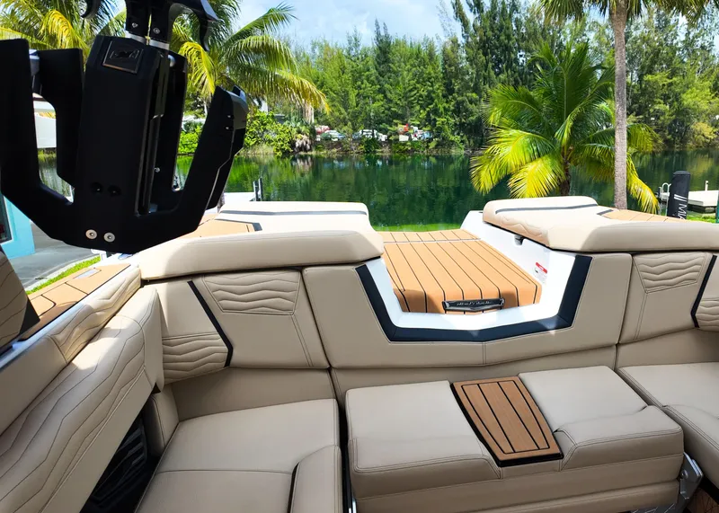 Slide: The Image of 2025 Nautique G23 boat interior with luxurious seating and scenic lake view. - 7