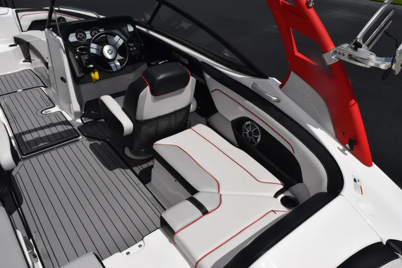 Slide: The Image of 2018 Yamaha Boats 212X interior with sleek seating, modern dashboard, and stylish red accents. - 10