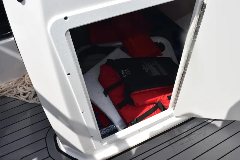 Slide: The Image of Storage compartment on 2018 Yamaha Boats 212X with life jackets and rope. - 16