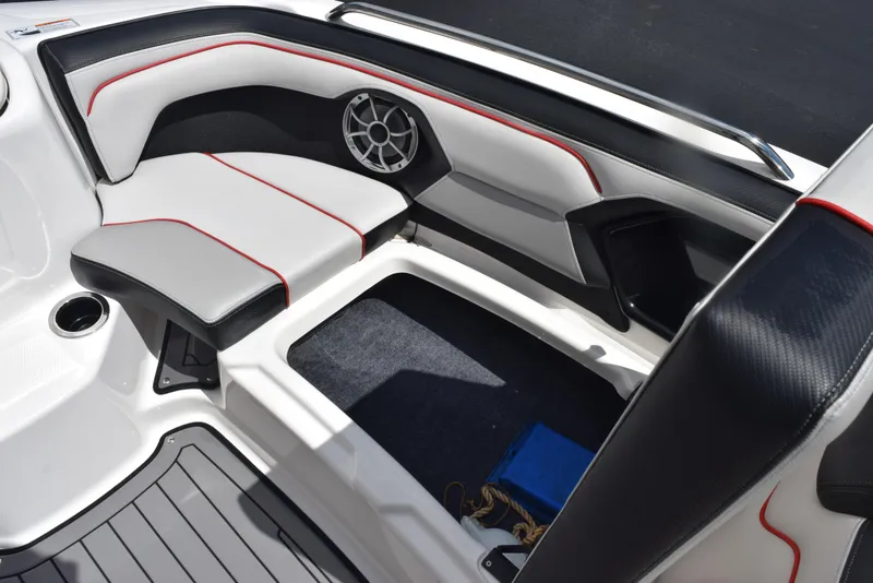 Slide: The Image of 2018 Yamaha Boats 212X interior seating with storage compartment and speaker. - 18