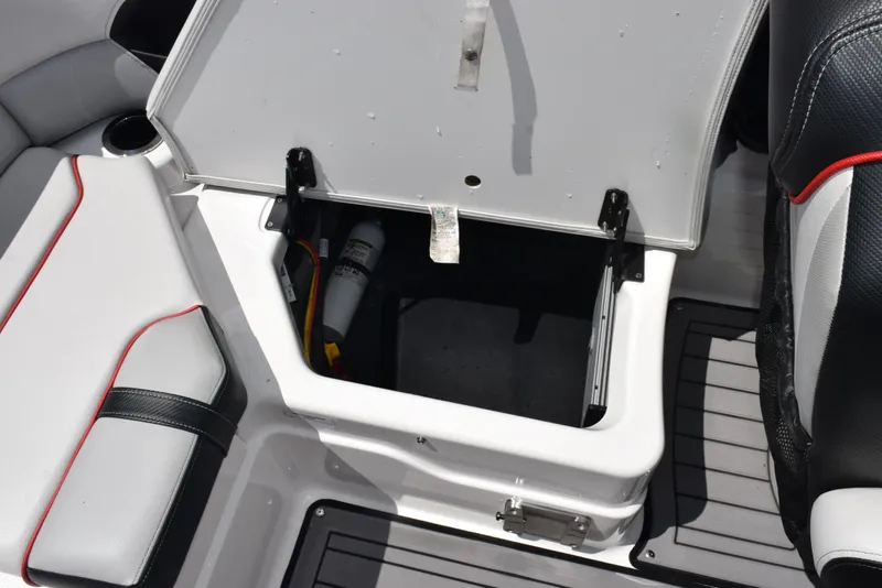 Slide: The Image of Open storage compartment on a 2018 Yamaha Boats 212X, featuring sleek seating and interior design. - 19