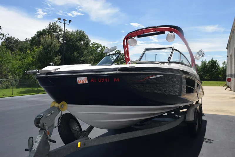 Slide: The Image of 2018 Yamaha Boats 212X on trailer, parked outdoors under a clear blue sky. - 4