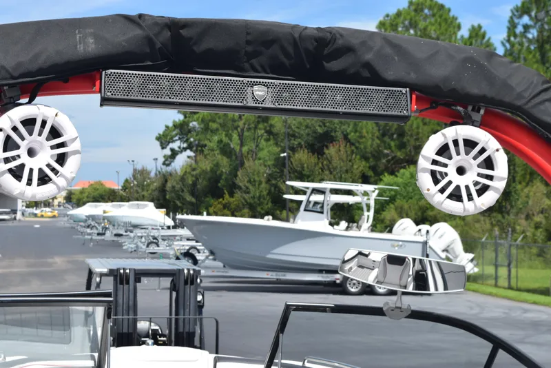 Slide: The Image of 2018 Yamaha Boats 212X with speakers and canopy, parked in a marina. - 7