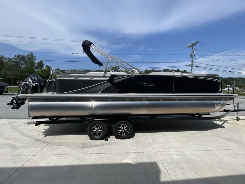 Slide: The Image of 2024 Tahoe Pontoon 25 LSZ QL on trailer, side view, outdoors under clear sky. - 10