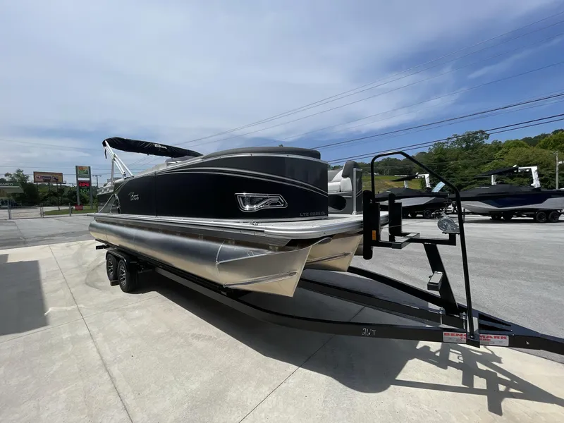 Slide: The Image of 2024 Tahoe Pontoon 25 LSZ QL boat on trailer, parked outdoors. - 11