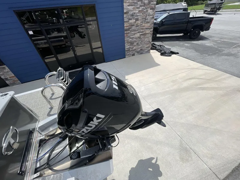 Slide: The Image of 2024 Tahoe Pontoon 25 LSZ QL with Suzuki outboard motor, parked near a building. - 14