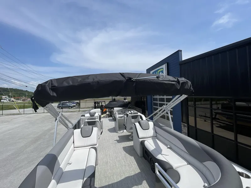 Slide: The Image of 2024 Tahoe Pontoon 25 LSZ QL with canopy, parked outdoors under clear sky. - 16