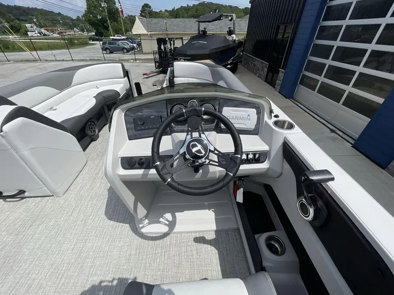 Slide: The Image of 2024 Tahoe Pontoon 25 LSZ QL boat interior with steering wheel and Garmin display. - 19