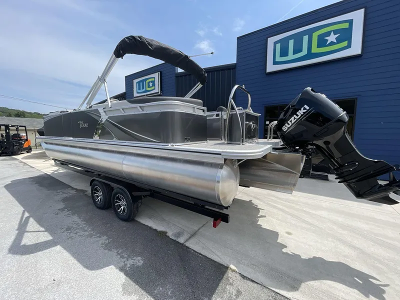 Slide: The Image of 2024 Tahoe Pontoon 25 LSZ QL with Suzuki engine on trailer, parked outside dealership. - 5