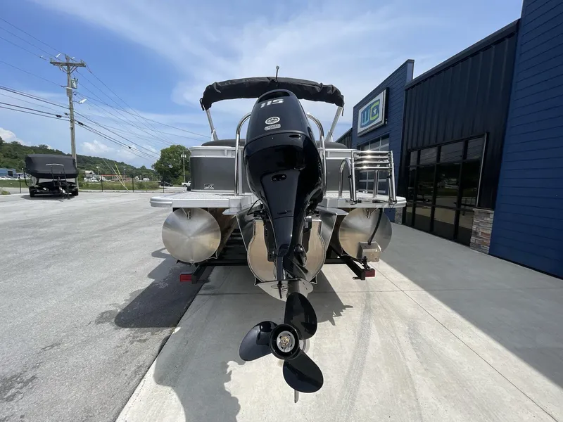 Slide: The Image of 2024 Tahoe Pontoon 25 LSZ QL with outboard motor, parked outside a building. - 6