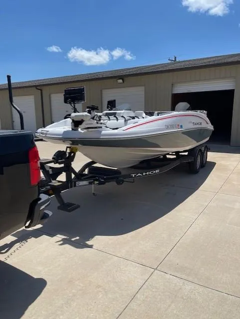 Slide: The Image of 2024 Tahoe 2150 boat on trailer, parked outside a garage under a clear blue sky. - 3