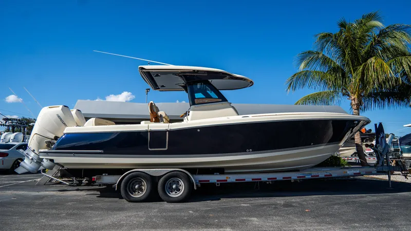 The Image of 2025 Chris-Craft Catalina 30 boat on trailer, parked under clear blue sky. - 0