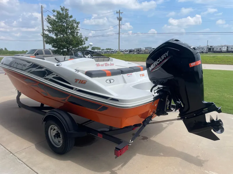 Slide: The Image of 2020 Tahoe T16 boat with Mercury engine on trailer, parked outdoors. - 2