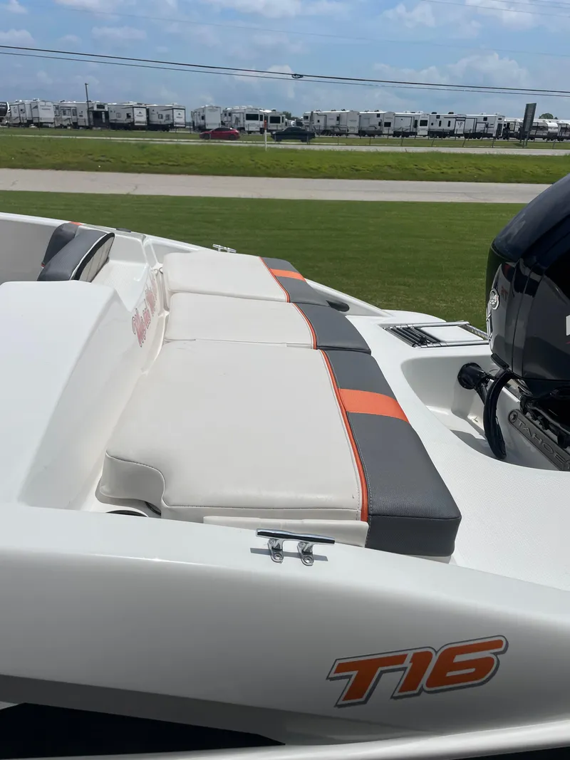 Slide: The Image of 2020 Tahoe T16 boat with cushioned seating and outboard motor, parked on grass. - 7