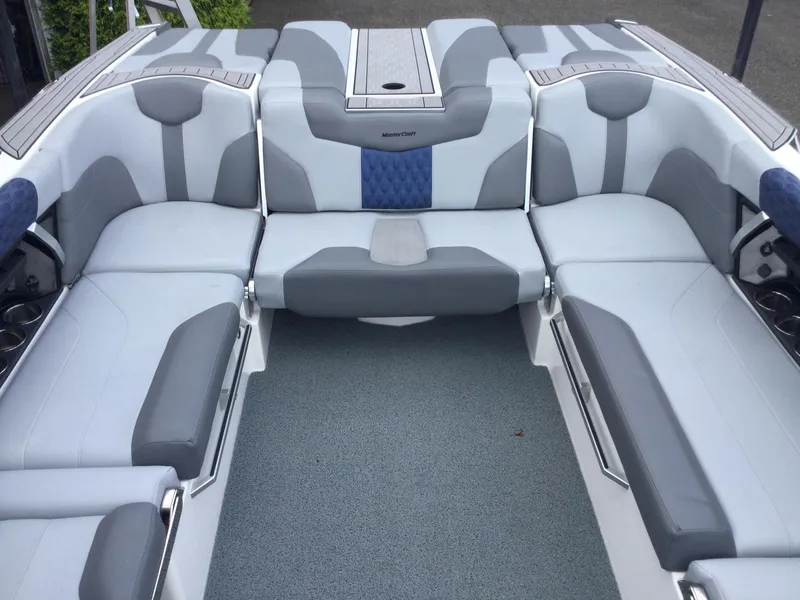 Slide: The Image of 2022 MasterCraft XT24 boat interior with gray and blue seating arrangement. - 11
