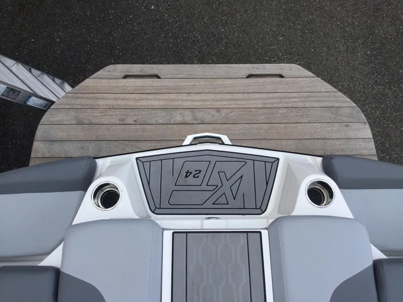 Slide: The Image of 2022 MasterCraft XT24 boat stern with teak swim platform and cup holders. - 13