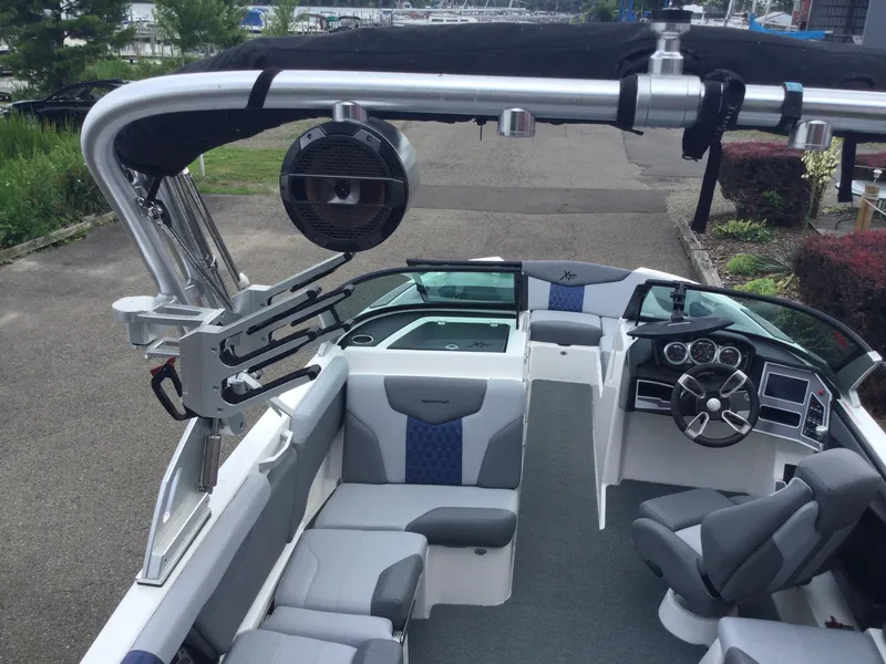 Slide: The Image of 2022 MasterCraft XT24 boat interior with sleek seating and advanced dashboard controls. - 14