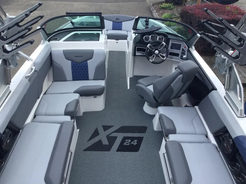 Slide: The Image of 2022 MasterCraft XT24 boat interior with gray seating and steering console. - 16