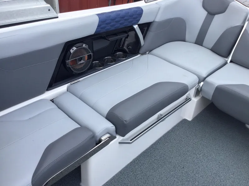 Slide: The Image of 2022 MasterCraft XT24 boat interior with gray seating and built-in speaker system. - 18