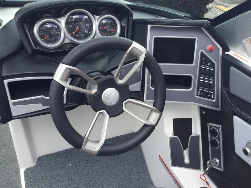 Slide: The Image of 2022 MasterCraft XT24 boat dashboard with steering wheel and control panel. - 19