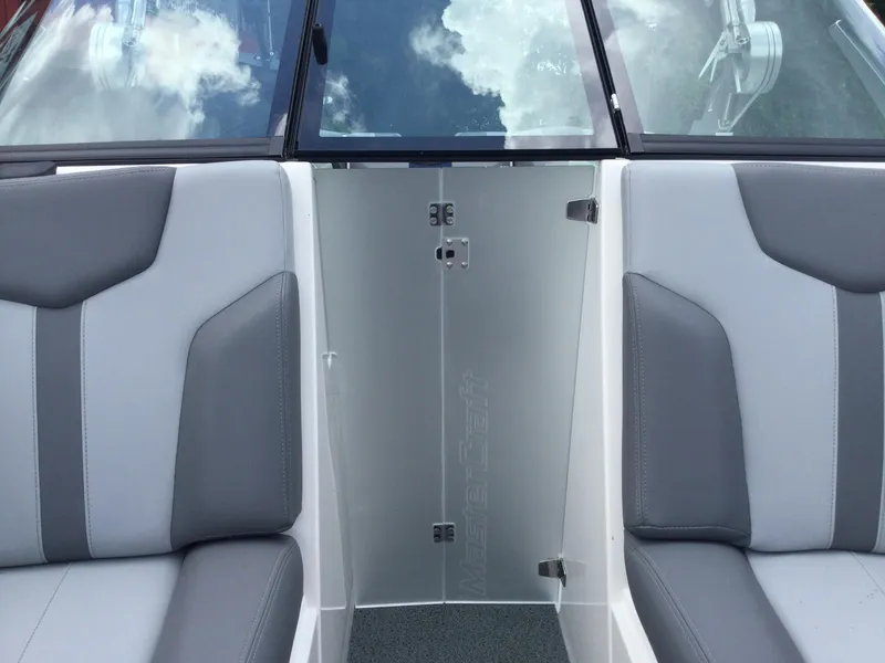 Slide: The Image of Interior of 2022 MasterCraft XT24 boat with gray seating and glass door. - 31