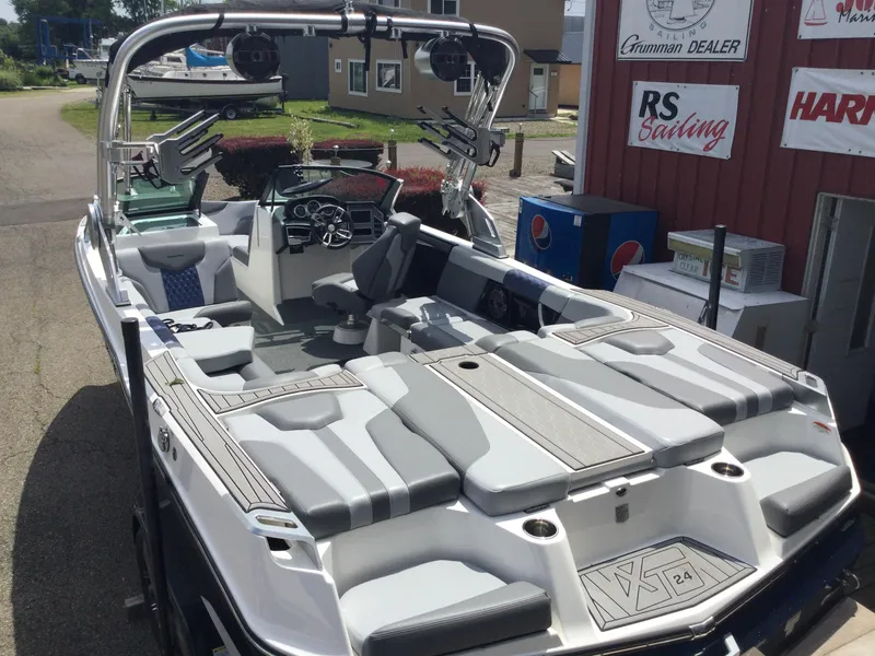 Slide: The Image of 2022 MasterCraft XT24 boat with sleek interior and advanced features, docked at a marina. - 6