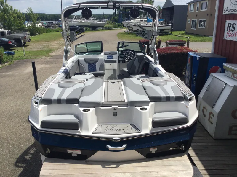 Slide: The Image of 2022 MasterCraft XT24 boat with spacious seating, docked outdoors. - 7