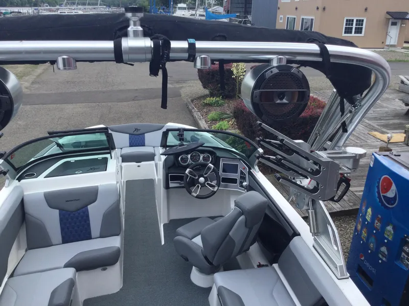 Slide: The Image of 2022 MasterCraft XT24 boat interior with seating, steering wheel, and audio system. - 9