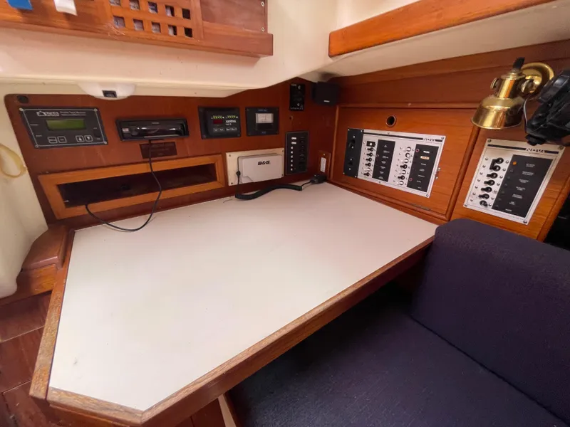 Slide: The Image of Navigation station of a 1987 Nonsuch 30 Ultra sailboat with control panels and equipment. - 16