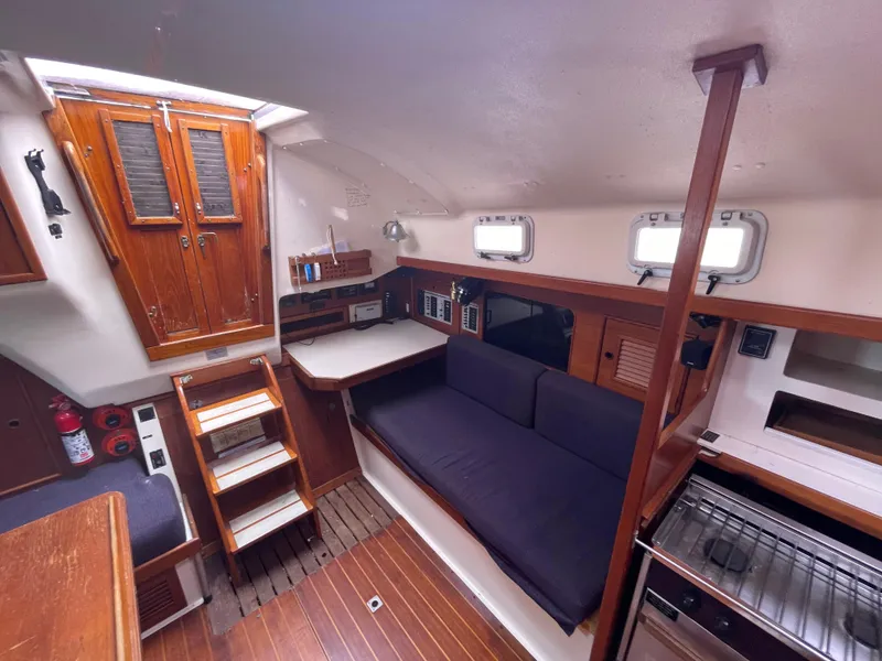 Slide: The Image of Interior of 1987 Nonsuch 30 Ultra sailboat with wooden cabinetry and seating area. - 19